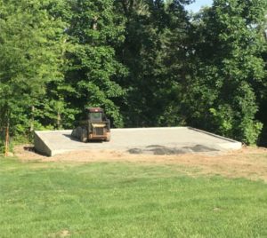 concrete wall being flattened in a grassy area