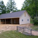 small horse run in shed with gray siding